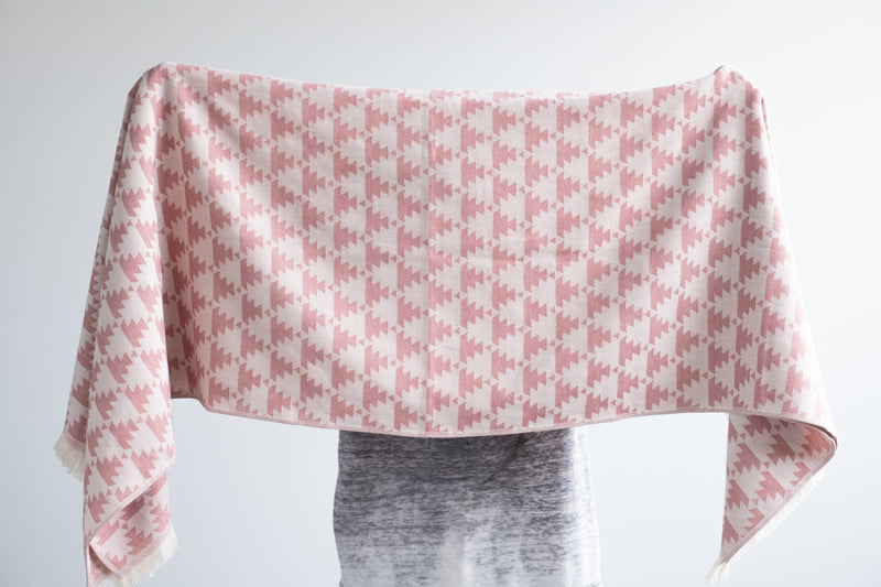 Woman shows open version of pink Freya Turkish bath towel Urban Pera 